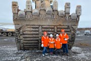 Aimee, Delphine, Julien and Nathan Munson stood in front of the bucket of an excavator at the Keetac mine during a tour in April.