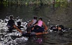 Migrants cross the Rio Grande as they try to get to the U.S. from the Mexican city of Matamoros on May 11. A surge of migrants is expected at the U.S.