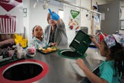 Jane Curtis-Cunningham helps first-grade students sort their food waste at Bel Air Elementary School in New Brighton.