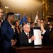 Gov. Tim Walz holds up a just-signed gun control bill on May 19 at the State Capitol in St. Paul. The sweeping public safety bill includes two gun mea