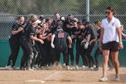 Stillwater catcher Sarah Dollerschell was greeted by teammates after she hit a home run May 10 against Park of Cottage Grove.