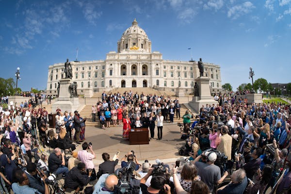 Along with DFL legislative leaders and his commissioners, Gov. Tim Walz threw a bill-signing party Wednesday morning on the Capitol steps.