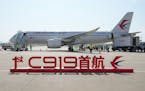 A sign which reads “1st C919 inaugural flight” is seen in front of the Chinese made passenger aircraft prepared for its first commercial flight fr