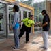 Security guards check identification for proof of age outside the Mall in Columbia, Friday, May 12, 2023, in Columbia, Md.
