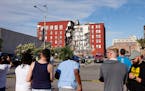 Onlookers watch as emergency crews work the scene of a partial building collapse on the 300 block of Main Street, Sunday, May 28, 2023, in Davenport, 