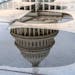 The U.S. Capitol is seen reflected in rain puddles on Monday, May 29, 2023, in Washington. After weeks of negotiations, President Joe Biden and House 