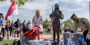 Megan Valentine, left, along with the help of Bob Wilts, right, reacts as she unveils a statue dedicated to her and her father Navy Seal and Special W