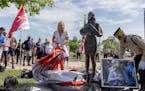 Megan Valentine, left, along with the help of Bob Wilts, right, reacts as she unveils a statue dedicated to her and her father Navy Seal and Special W