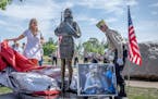 Megan Valentine, left, along with the help of Bob Wilts, right, unveils a statue dedicated to her and her father Navy Seal and Special Warfare Operato