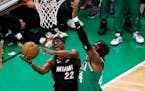 Heat forward Jimmy Butler, left, shot as Celtics center Robert Williams III defended during the second half Monday night in Boston.