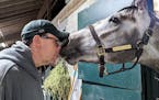 Joe Lejzerowicz rubs noses with colt Freezing Point, aka “Snowball,” at their barn at Keeneland in Lexington, Ky., March 19, 2023.