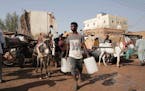 People gather to collect water in Khartoum, Sudan, Sunday, May 28, 2023. The Sudanese army and a rival paramilitary force, battling for control of Sud