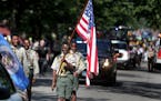 Members of the Pilgrim Baptist Church Troop 61 Boy Scouts lead the flag ceremony at the start of the 34th Annual Rondo Days Parade along Central Avenu