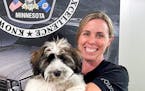 Police Detective Andrea Newton holds Doc, the Burnsville Police Department’s new wellness dog.