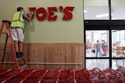 Jacob Meister, an installer with Electro Signs, put the Trader Joe’s sign up at the store on South Washington Avenue to prepare for the 2018 opening