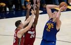 Nuggets center Nikola Jokic shoots over Heat forwards Duncan Robinson, left, and Haywood Highsmith during the first half of Game 1 of the NBA Finals
