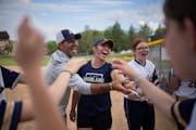 Head coach Anna Caruso, center, and her assistant and father Glenn, led their softball team in a cheer between innings Thursday.