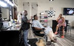 Teto Wilson cut the hair of Bernard Beamon while chatting with Audua Pugh on Friday about the coming Blue Line extension at Wilson’s Image in north 