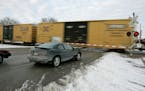FILE - Cars wait for a train to pass, in Valley, Neb., Wednesday, Jan. 17, 2007. With the rail industry relying on longer and longer trains to cut cos
