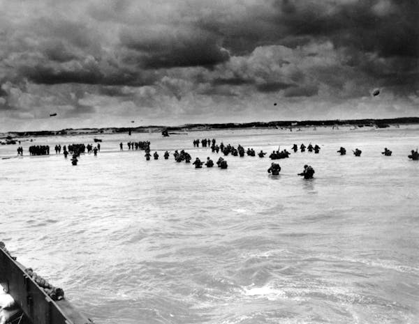 U.S. reinforcements wade through the surf as they land at Normandy in the days following the Allies’ D-Day invasion of occupied France in June 1944.