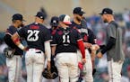 Minnesota Twins starting pitcher Pablo Lopez, second from right, hands the ball to manager Rocco Baldelli, right, during the sixth inning of a basebal