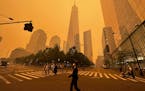 Pedestrians pass the One World Trade Center, center, amidst a smokey haze from wildfires in Canada, Wednesday, June 7, 2023, in New York. (AP Photo/Ju