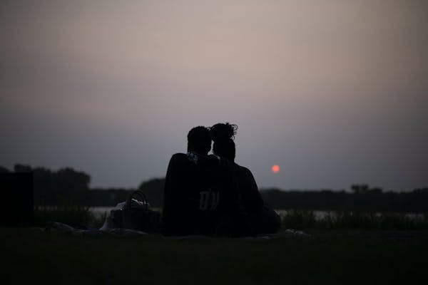 A couple watches the sun set over Crystal Lake on May 16, 2023. Wildfire smoke is expected to create poorer air quality conditions for the remainder o