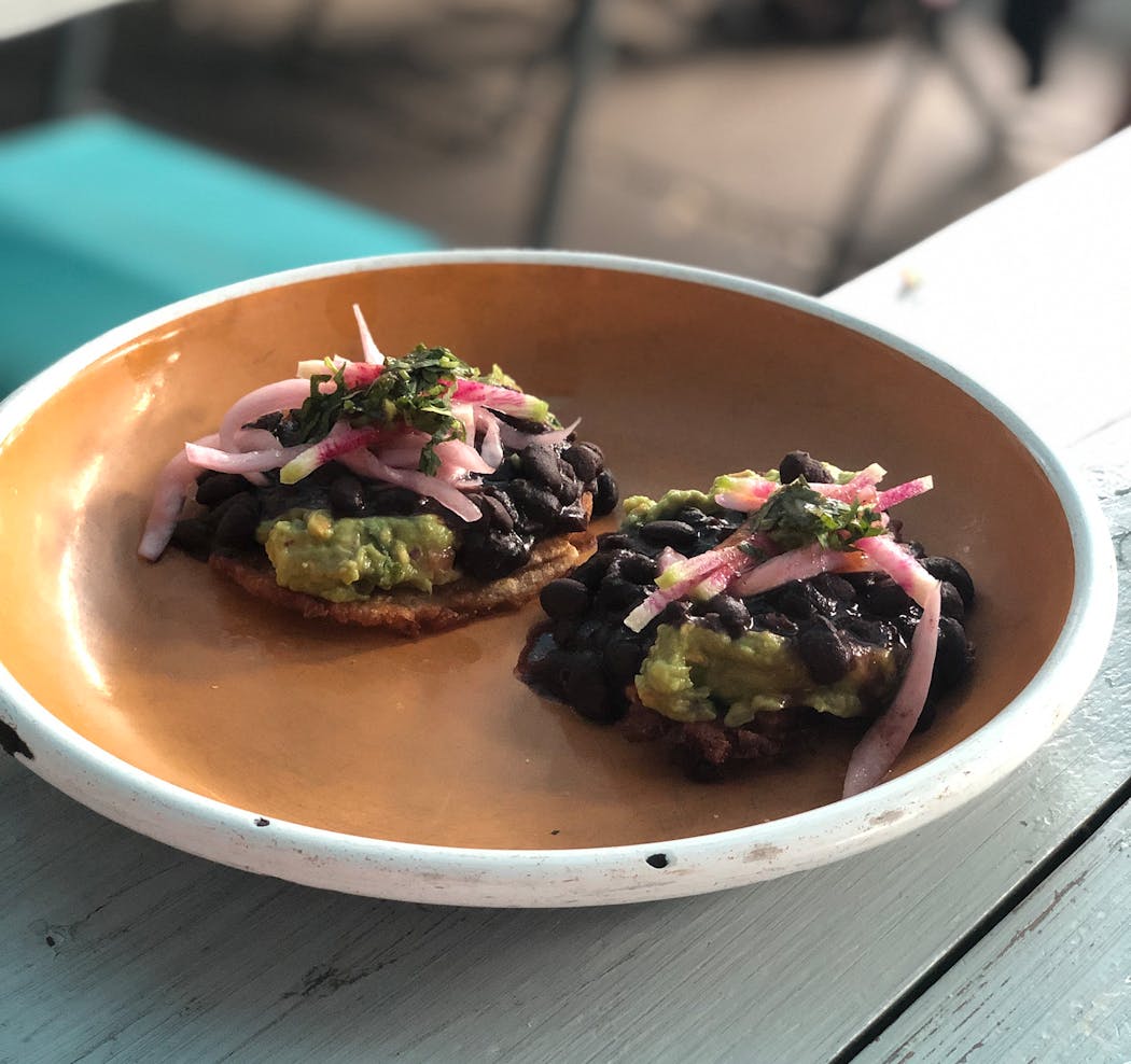 At Hola Arepa, tostones come with shredded beef or this vegan guacamole-black bean version.
