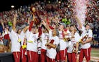 Oklahoma players celebrate with the trophy after defeating Florida State in the NCAA Women’s College World Series championship 
