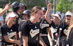 Mankato East outfielder Emily Hacker (1) is met by her teammates at home plate after hitting a home run against Chisago Lakes in the seventh inning of