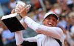 Poland’s Iga Swiatek holds the trophy as she celebrates winning the women’s final match of the French Open tennis tournament against Karolina Much