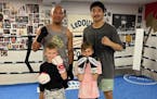 Caleb Truax (left) and rising amateur Jimmy Vang, with 8-year-old pugilists Chev Addyman (left) and Rory Shelstad at Lyke’s Gym.