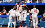 Carlos Correa celebrates with his teammates after hitting a grand slam against the Blue Jays during the eighth inning Saturday in Toronto. 