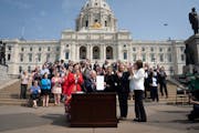 Gov. Tim Walz signs a ceremonial budget bill on the Capitol steps in front of hundreds of supporters on Wednesday, May 24, 2023.