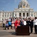 Gov. Tim Walz signs a ceremonial budget bill on the Capitol steps on May 24 in St. Paul.