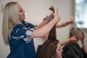 Emily Olson, a stylist at Hair District Collective in St. Louis Park, cuts a client’s hair on Thursday, June 29. Olson left her job during the Great