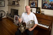 Bill Webb at his home with his two favorite instruments: the trumpet and French horn. Webb taught band for more than 30 years in Edina and was recentl