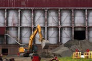 Crews work earlier this month to remove fine crushed taconite ore from the old LTV Steel mill in Hoyt Lakes, where PolyMet wants to locate it processi