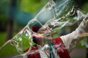 Lawrence Ripp, a soap bubble entertainer known as the Baron of Bubble, busking at Minnehaha Falls Park in Minneapolis in 2020.
