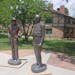 Statues of J. Robert Oppenheimer, left, and Gen. Leslie Groves stand outside the historic Fuller Lodge in Los Alamos, N.M.