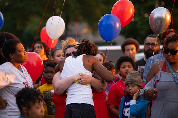 Danielle Pickett and Rashad Cobb, Ricky Cobb II’s twin brother, embraced at the vigil. Danielle and Ricky’s two children are at right. A vigil for