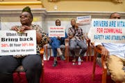 Minneapolis ride-share drivers and supporters held up signs while City Council members discussed an ordinance raising driver pay on Aug. 17.