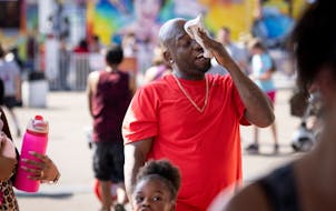 Kenneth Shutes brought a towel to mop his brow as he played games with his family on the midway on the final day of this year’s State Fair on Monday