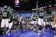 Coach Chris Creighton, middle left, led his Eastern Michigan team onto the field against Pittsburgh in the 2019 Quick Lane Bowl at Ford Field in Detro