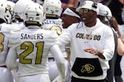 Colorado head coach Deion Sanders, right, talks to safety Shilo Sanders (21) during the first half of an NCAA college football game against TCU Saturd