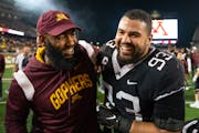 Gophers defensive lineman Kyler Baugh (93) celebrated with defensive line coach Winston DeLattiboudere III after recording a sack to end Saturday nigh
