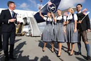 Timothy Liston, U.S. Consul General in Munich, smiles with a Lufthansa crew in traditional Bavarian costume prior to a flight bound for Miami at Munic