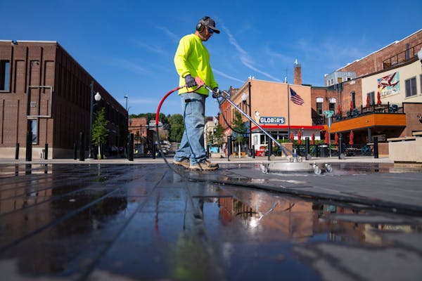 Joel Jordan cleaned part of the new plaza leading to the historic Stillwater Lift Bridge on Thursday. Portions of Main Street that have been closed du