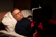Firefighter Jeremy Norton reads “Black Man in a White Coat” in his bed before he tries to nap at Fire Station 17 in Minneapolis.