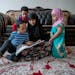 Fardowsa Bashir sat with her children, Saadiq Dahir, 6, left, Sadri, 2, center, and Anzal, 3, right, as she listened to them read to her in her home i